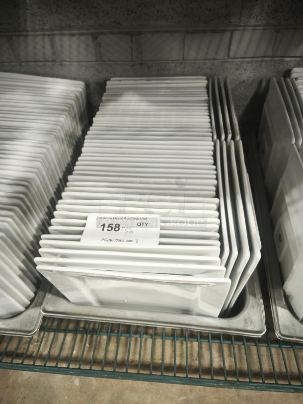 Stack of 9" bright white square porcelain plates on a rack. Quantity label indicates 158 plates. Excellent condition.