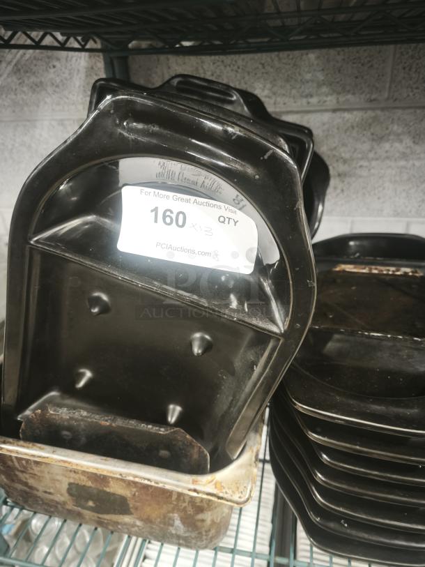 Iron griddle pan with visible wear, stacked on a shelf. Label shows “160 x 3 QTY” for auction reference.
