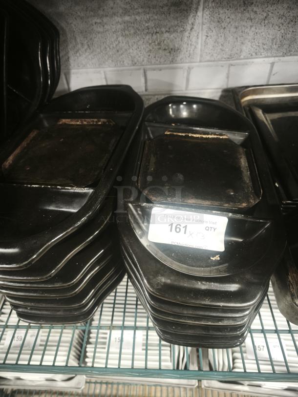 Stack of iron griddle pans, black finish, showing signs of wear. Auction label reads "161, QTY 3" with website link.