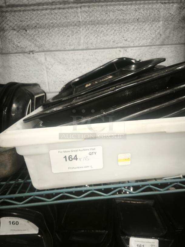 Black hot stone serving platter set in tray, used, stacked on shelf. Label reads: "For More Great Auctions Visit PCIAuctions.com". Quantity: 16.