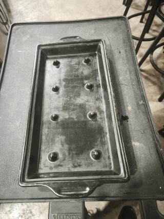 Black stone serving platter with textured surface and integrated handles, used for bar and grill service; shows signs of use.