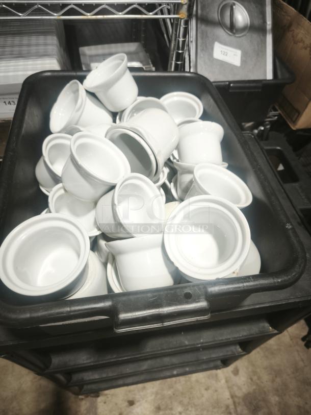 Aluma White Medium Porcelain Pot Pie Dishes stacked in a black bin, showcasing their uniform glossy finish and clean condition.