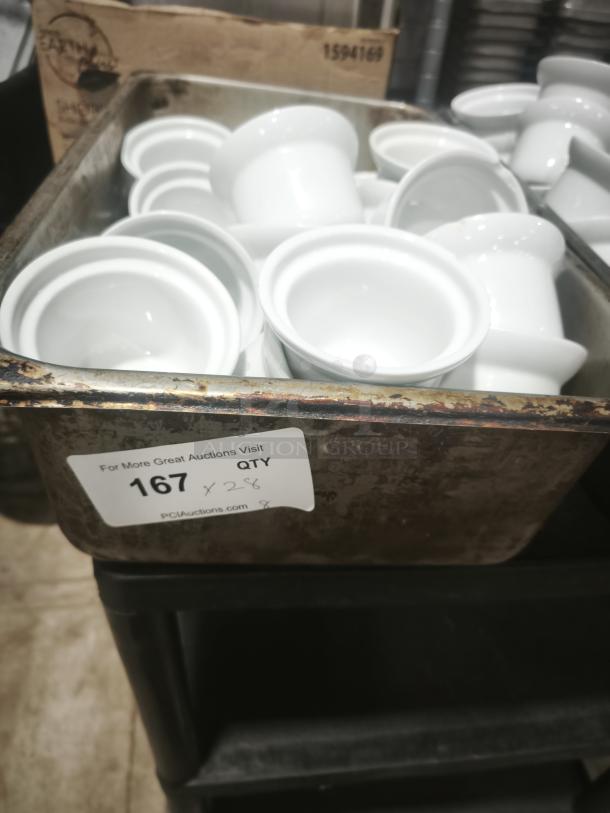 Aluma White Medium Porcelain Pot Pie Dishes in a metal tray, stack of 28, pristine condition, auction label visible.