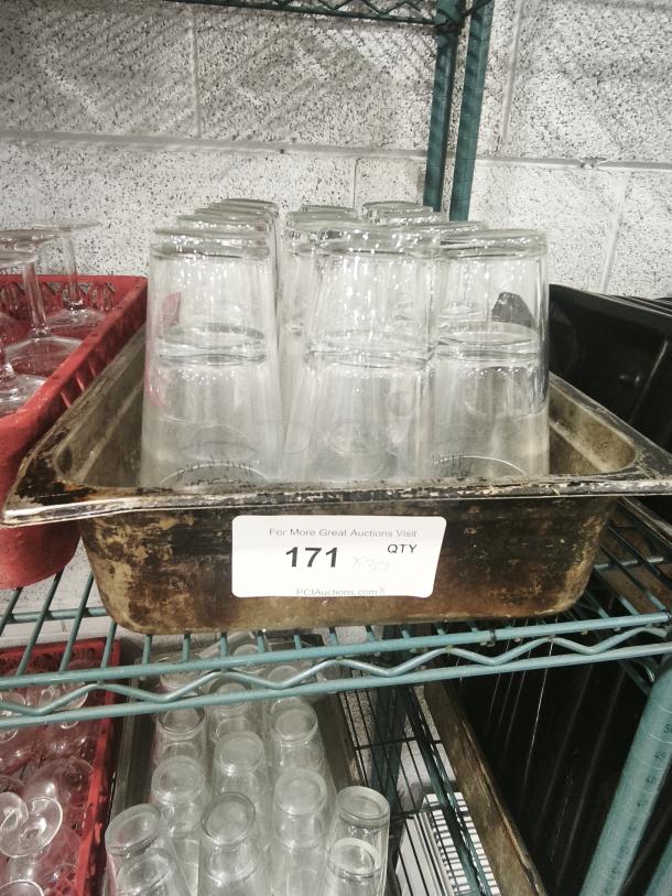 Vintage glass tumblers in metal tray, 30 pieces, good condition. Auction tag "171 x30" visible. Ideal for collectors.