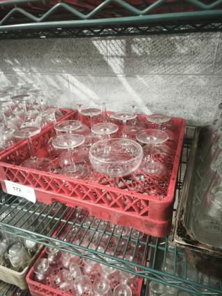 Vintage footed glass low sherbet bowls displayed in red crate on metal shelf. Good condition with clear glass design.