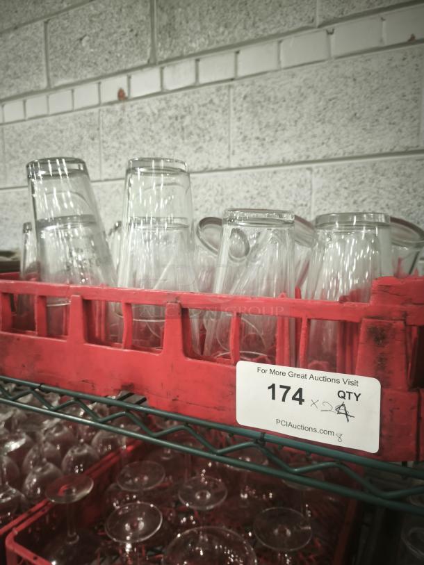 Vintage glass tumblers in a red crate, suitable for restaurant use. Stack of clear, cylindrical glasses in good condition.
