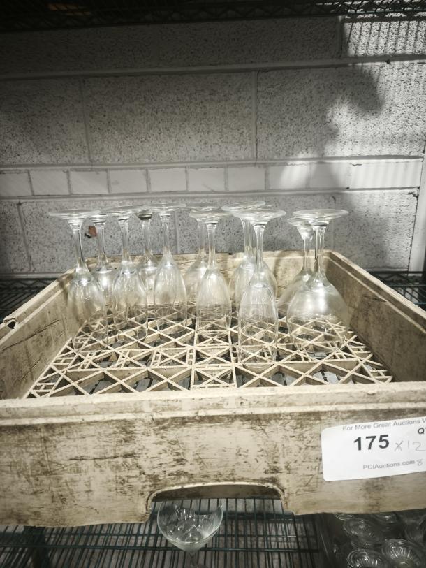 Fluted champagne glasses with clear swirl design, set of 12, in good condition, displayed in a rustic crate.