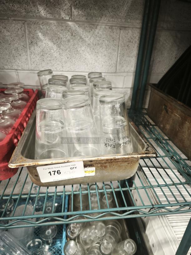 Vintage glass tumblers, restaurant style, in a metal tray. Approximately 20 pieces, clear glass, good condition. Auction lot 176.