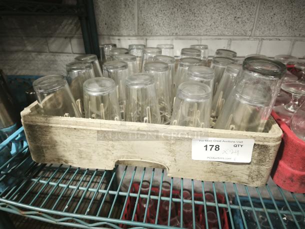 Vintage glass tumblers in a storage crate. Quantity: 24. Condition appears used. Auction tag number 178 visible.