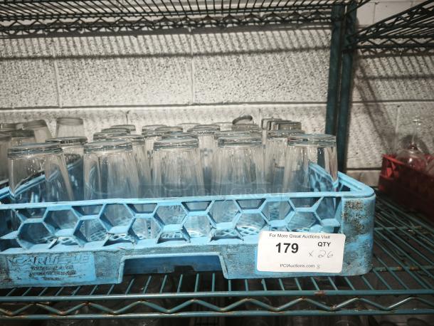 Vintage glass tumblers in a blue rack, 26 count. Marked with auction label "179." Used restaurant condition.
