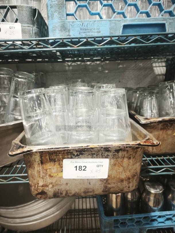 Vintage glass tumblers, quantity 45, in used condition. Displayed in a metal tray with visible wear, marked "182 QTY 45".