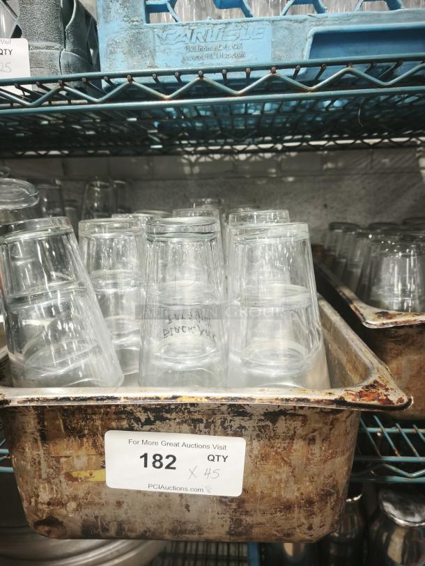 Vintage restaurant glass tumblers in worn metal tray, 45 pieces. Clear glass, tapered shape, used condition. Item tag indicates qty.