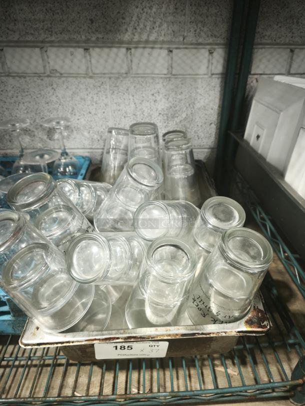 Vintage glass tumblers in a metal tray, clear glass, cylindrical shape, used condition, auction tag labeled “185.”