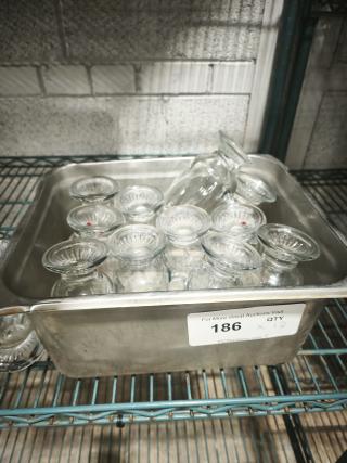 Set of clear glass footed items, 6" tall, in a metal container. Includes twelve pieces, in excellent condition. Auction lot 186.