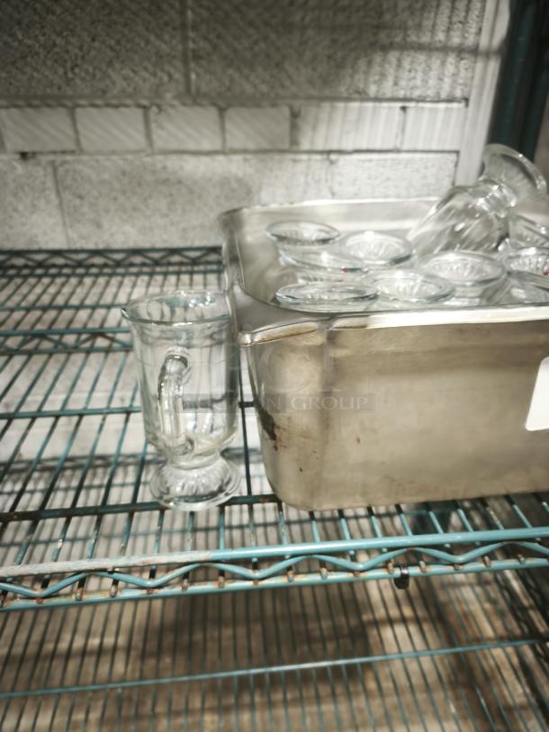 Clear glass footed mug, 6 inches tall, displayed upright. Features a sturdy handle and detailed base design, in good condition.