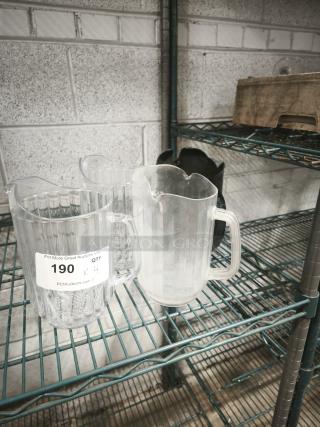 Clear and frosted plastic pitchers on wire shelf, one labeled "190 QTY 4" by PCI Auctions, indicating a set.