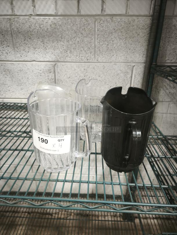 Clear and black plastic pitchers on a metal shelf, one marked with "190 QTY 4" label, in good condition.