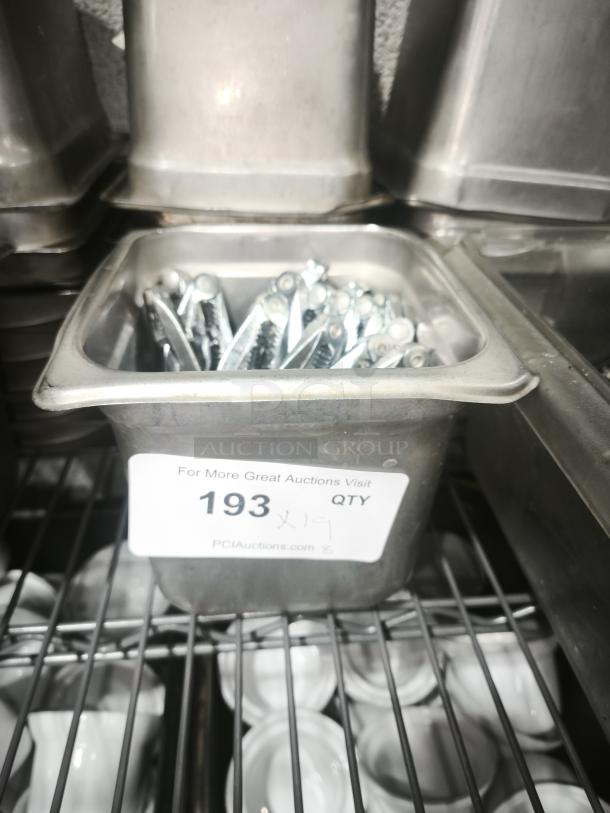 Stainless steel crab crackers and tools set in a metal tray. Label reads "193 QTY, PCI Auctions." Item appears unused.