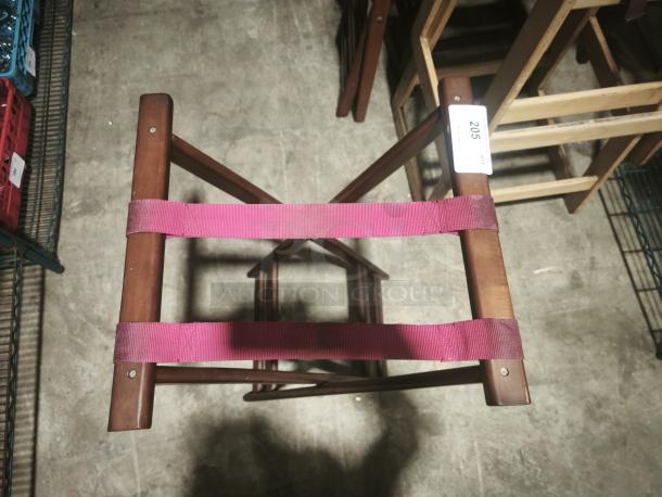 Folding mahogany wooden tray stand, 32-1/4" high, with red fabric straps. Auction tag labeled "205".