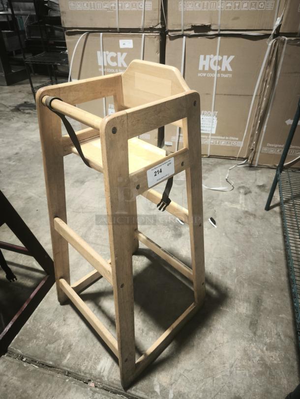 Solid wood high chair with seat belt, in good condition. Ideal for infants. Tag reads "214."
