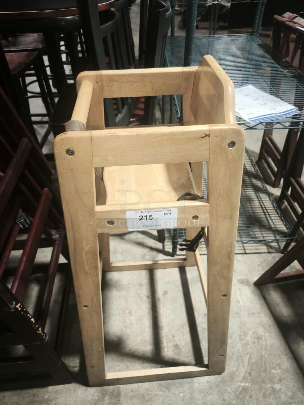 Solid wood high chair, sturdy, in good condition with a natural finish. Auction label reads "215 QTY."
