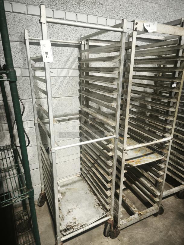 Aluminum bakers rack with multiple shelves, used condition, rolling casters, item tag number 218 visible.