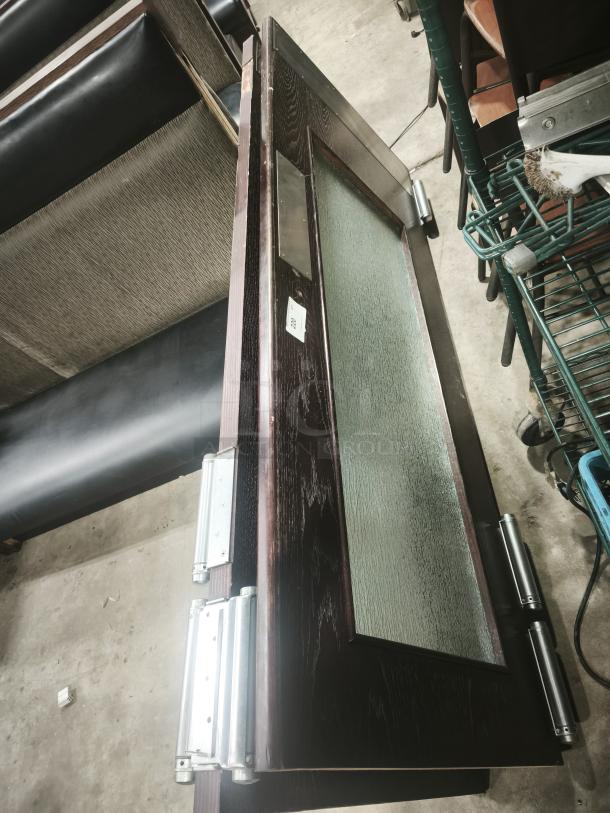 Solid wood double sliding door with glass panel and grill design. Modern style, excellent condition, visible hinge brackets.