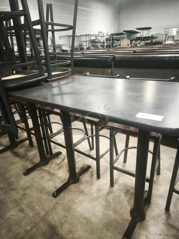 Premier Café Height Table in an industrial setting, black metal base, wooden top, numbered tag attached, used condition.