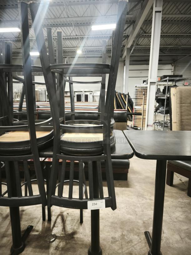 Metal dining chair with slatted back and mahogany wood seat, stacked on table. Good condition with visible tag reading "234."