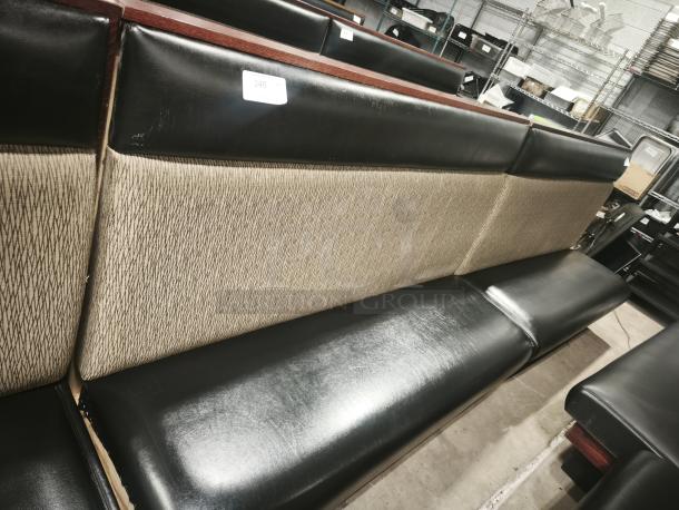 Double mid-channeled restaurant booth with headroll, featuring black leatherette seating and beige patterned backing. Good condition.