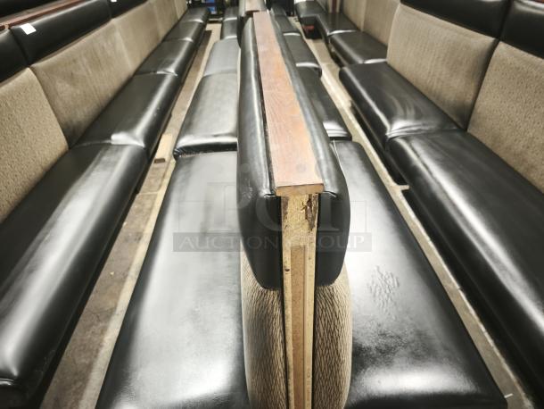 Double mid-channeled restaurant booth with headroll, featuring black vinyl seats and fabric backrests. Some wear visible.