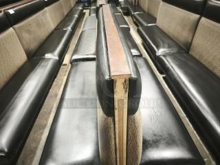 Double mid-channeled restaurant booth with headroll, featuring black vinyl seats and fabric backrests. Some wear visible.