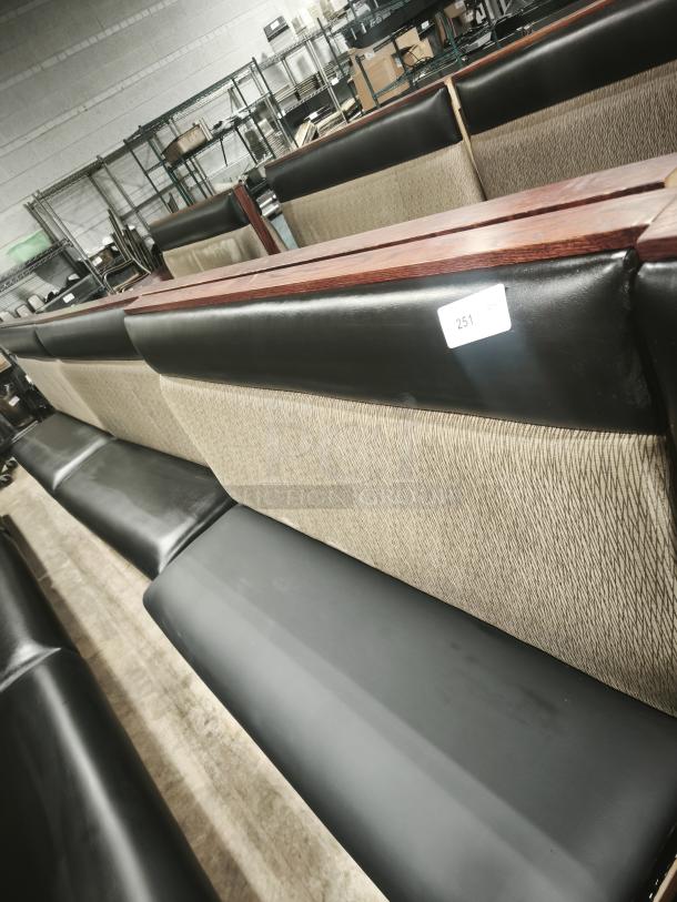 Single mid-channeled restaurant booth with headroll, beige and black upholstery, wooden accents, tag numbered 251.