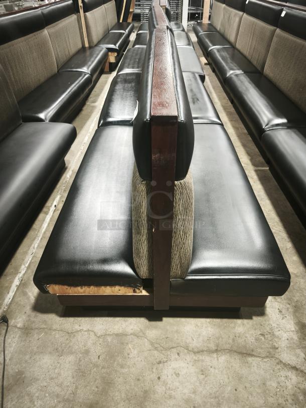 Double mid-channeled style restaurant booth with headroll, black upholstery, wood accents; slight visible wear on corners.