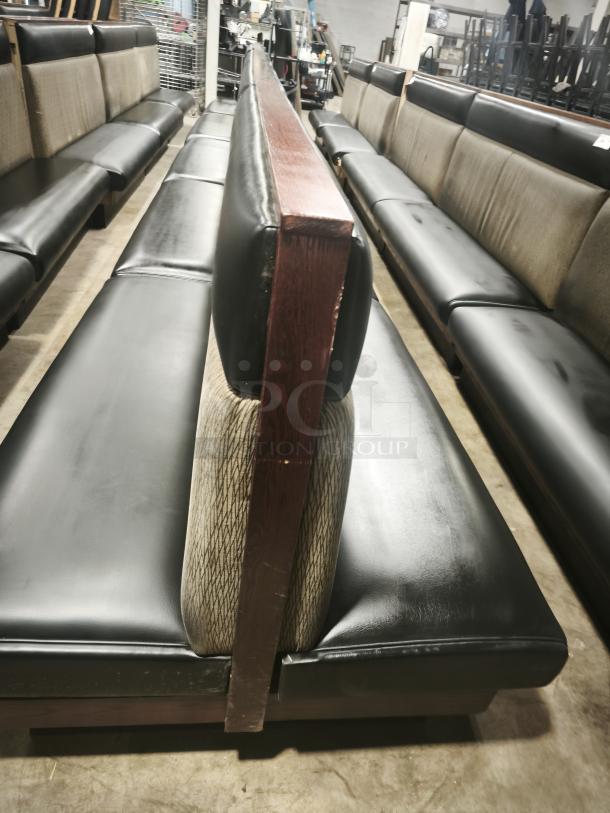 Double mid-channeled restaurant booth with headroll, black upholstery, in good condition. Features wooden backing.