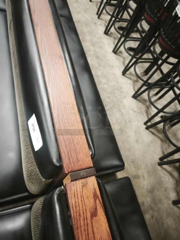 Double mid-channeled black restaurant booth with wood headroll, good condition, labeled with item number 256.