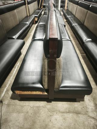 Double mid-channeled restaurant booth with headroll, featuring black and patterned upholstery, visible wear on edges.