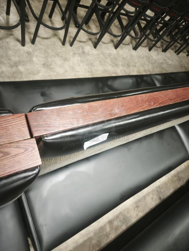 Double mid-channeled restaurant booth with headroll featuring black vinyl and wood paneling, item tag labeled "257".