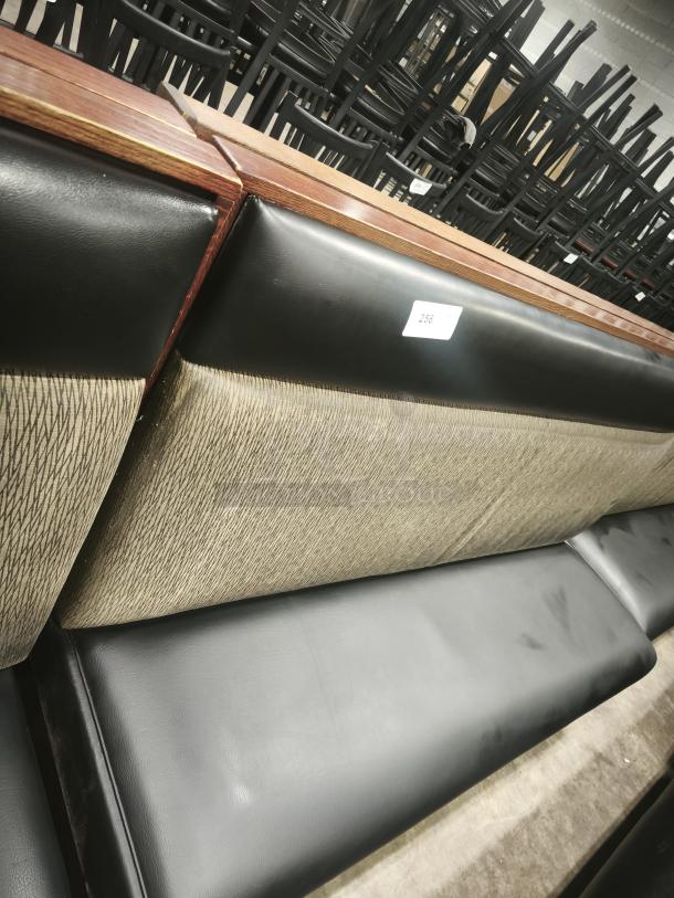 Single mid-channeled restaurant booth with headroll, black and beige upholstery, wooden accents, tag numbered 258.