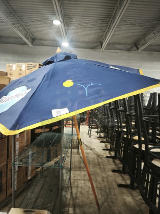 Blue Moon patio beer umbrella with blue and yellow accents, featuring brand logo. Good condition, suitable for bar or restaurant use.