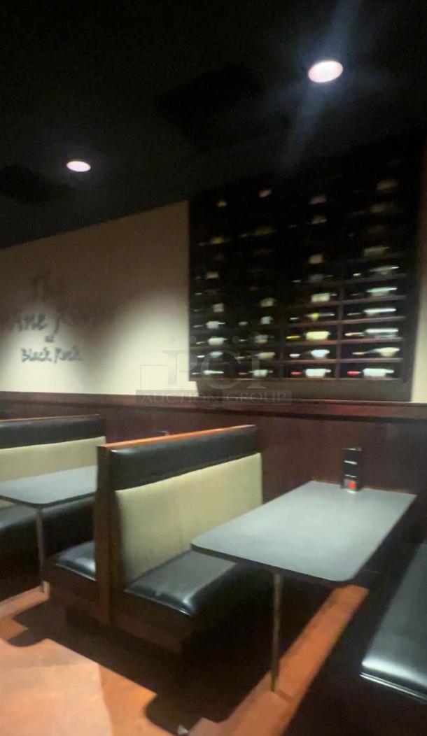 Rectangular table with gray top, designed for fixed booth seating.  Black leather booths, wooden backing, good condition.