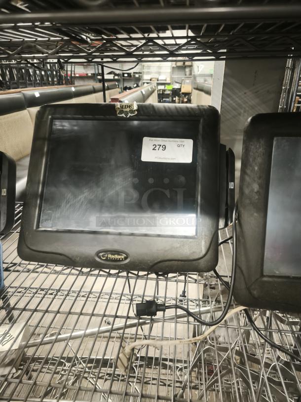 Radiant Systems POS display monitor on shelving, showing signs of wear. Label indicates auction lot number 279.
