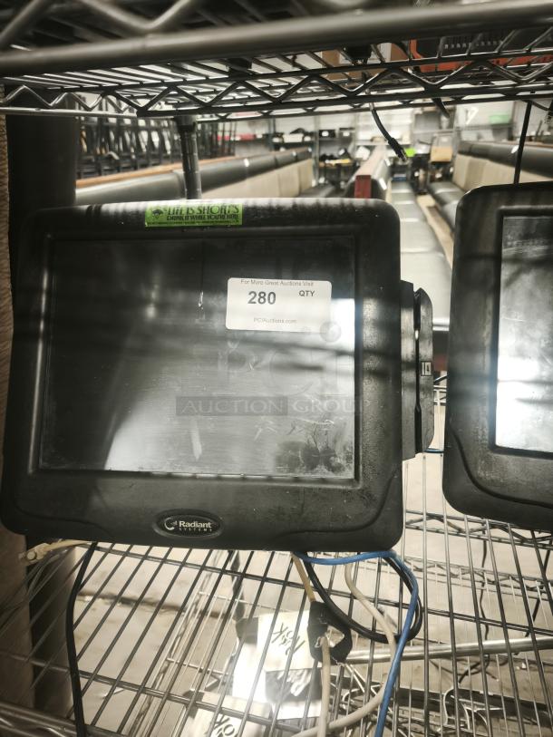 Radiant Systems POS display monitor on a shelf, minor wear, cables attached. Label reads "280 QTY PCIAuctions.com."