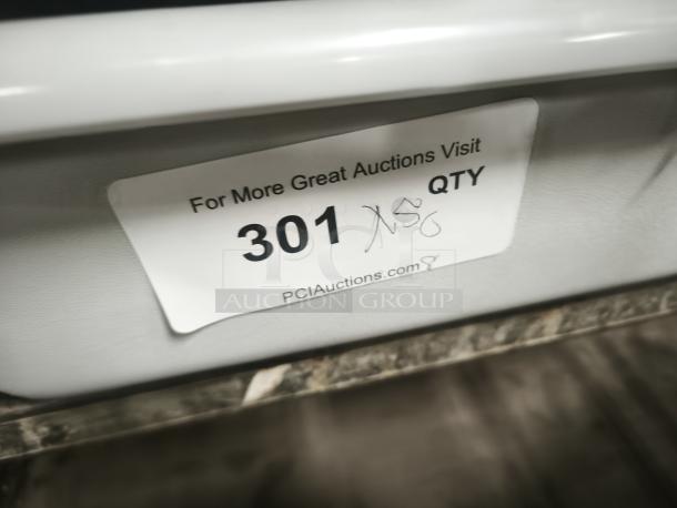 A label indicating auction item number 301 and quantity. No silverware or black towel visible.