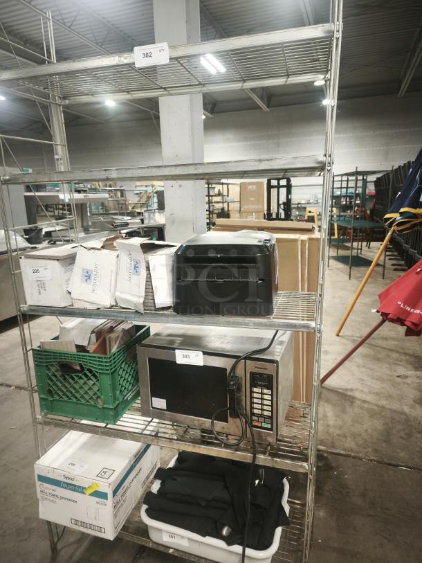 5-tier metal shelving unit with S-hooks, holding boxes and appliances. Visible labels indicate auction lot numbers. Used condition.