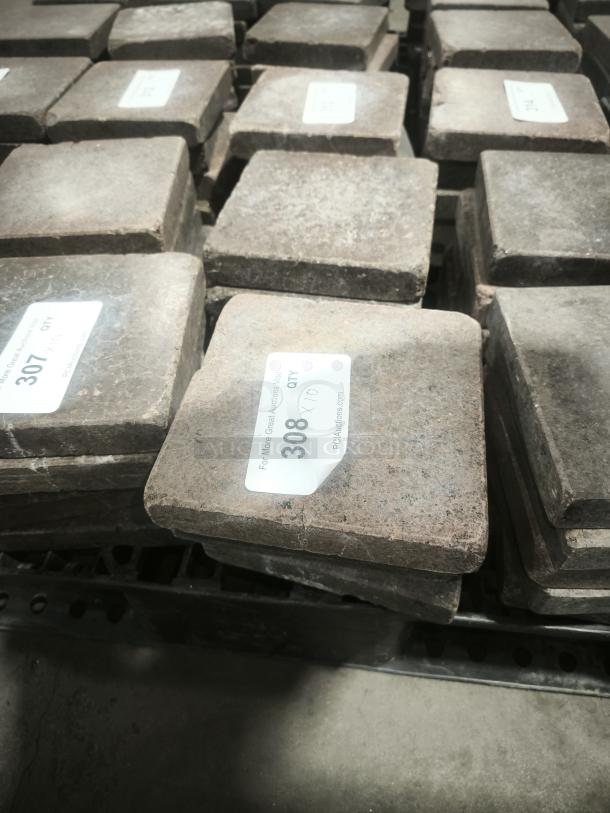 NSF Certified volcanic granite slabs for cooking; shows item tags with lot numbers; in stack, in good condition.