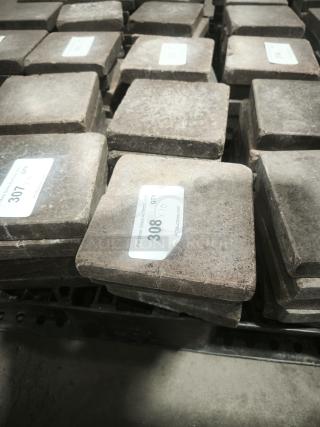 NSF Certified volcanic granite slabs for cooking; shows item tags with lot numbers; in stack, in good condition.