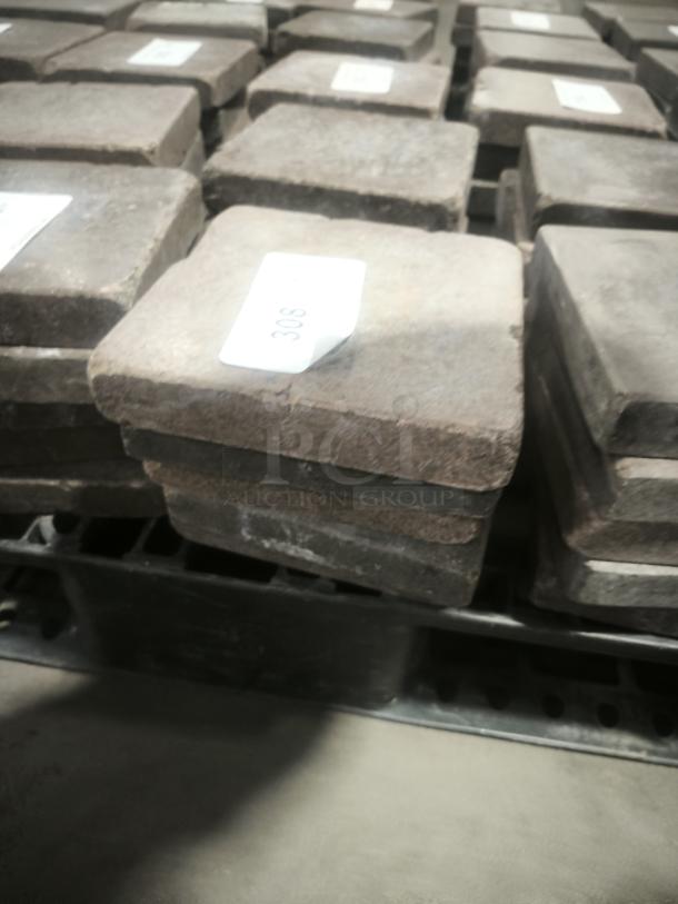 NSF certified volcanic granite slabs for cooking, square shape, stacked on a pallet, labeled with numbers.