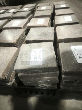 Volcanic granite slabs for cooking, NSF certified, stacked with visible item labels.