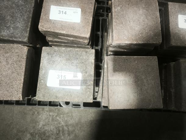 NSF Certified volcanic granite slabs for cooking food, shown stacked, each with adhesive labels indicating auction quantity and details.